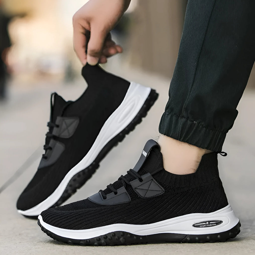 Low-top Flyknit sports trainer in black with mesh lining and lace-up front, shown on a white background.