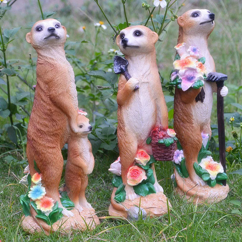 Three straw hat mongoose garden ornaments including mother and child grouping plus figures with rake and shovel