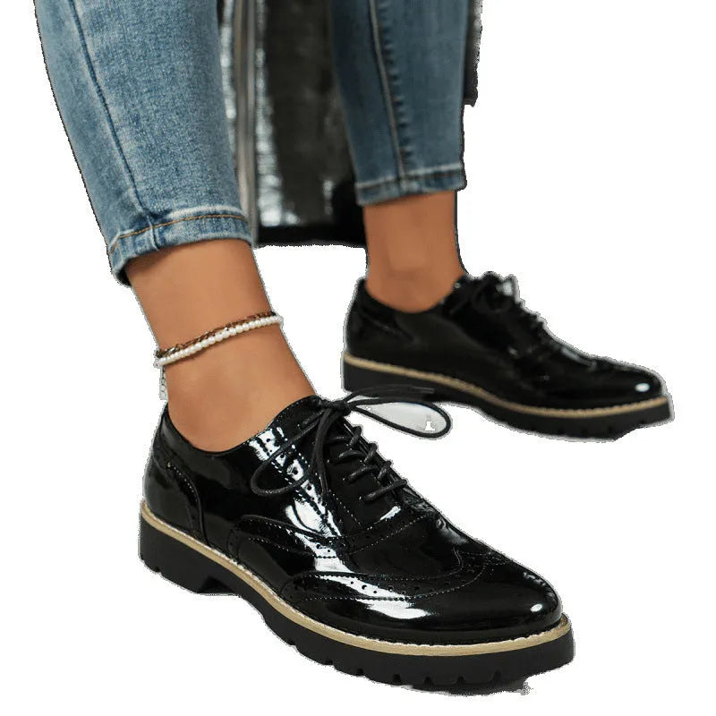 Women's black lace-up loafers with wedge heels and sequin detailing, showing round toe and mid-cut design