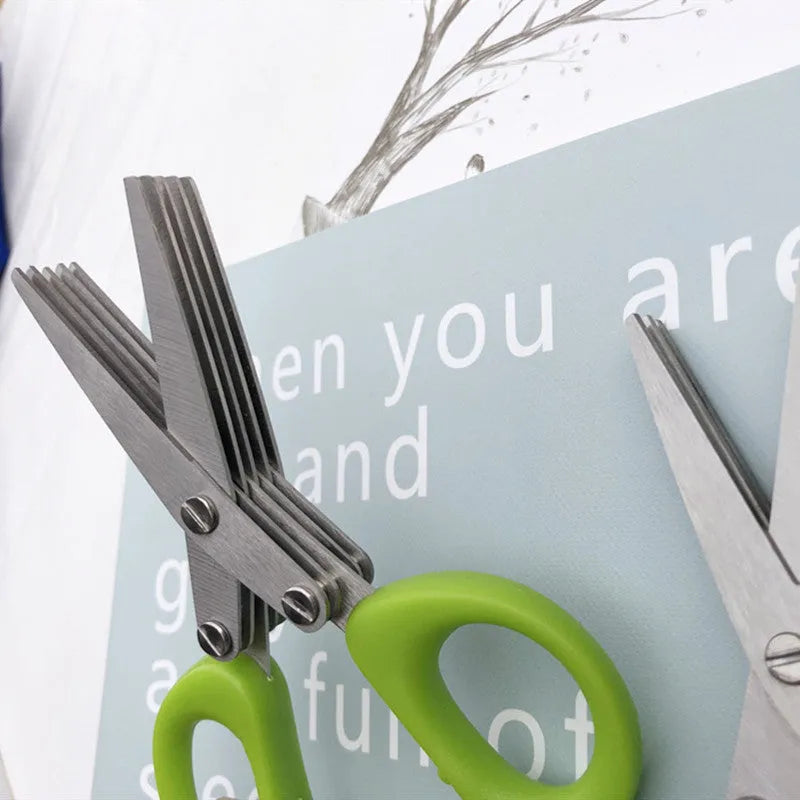 Stainless steel multi-layer kitchen scissors for cutting green onions and herbs on a chopping board.