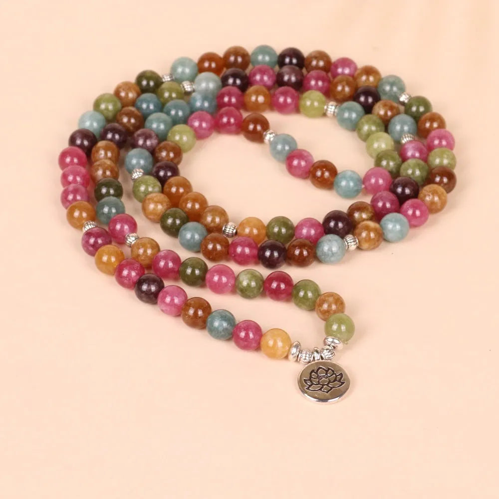 108 bead multi-layer bracelet in tourmaline colour with alloy details on a wrist.