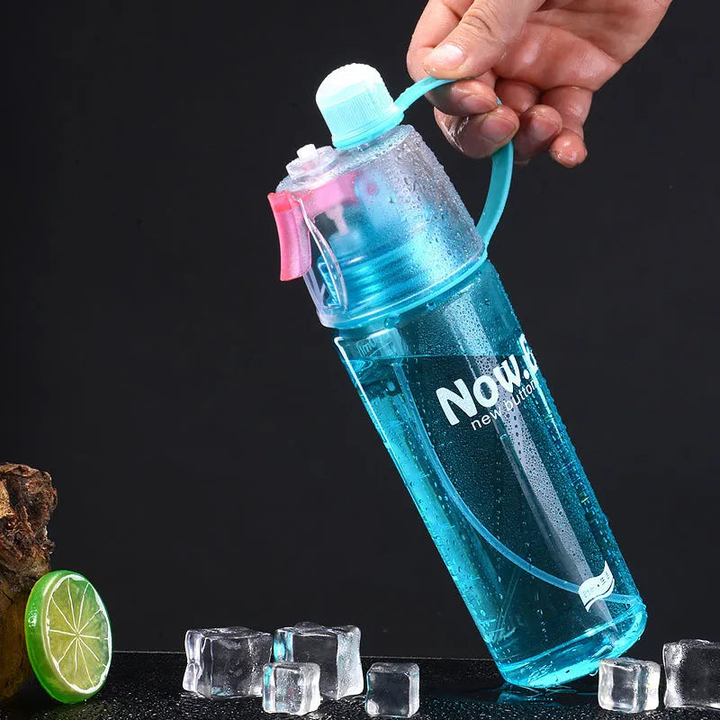 Green portable sports mist spray cup with transparent body, volume scale, handle, and spray mouth.