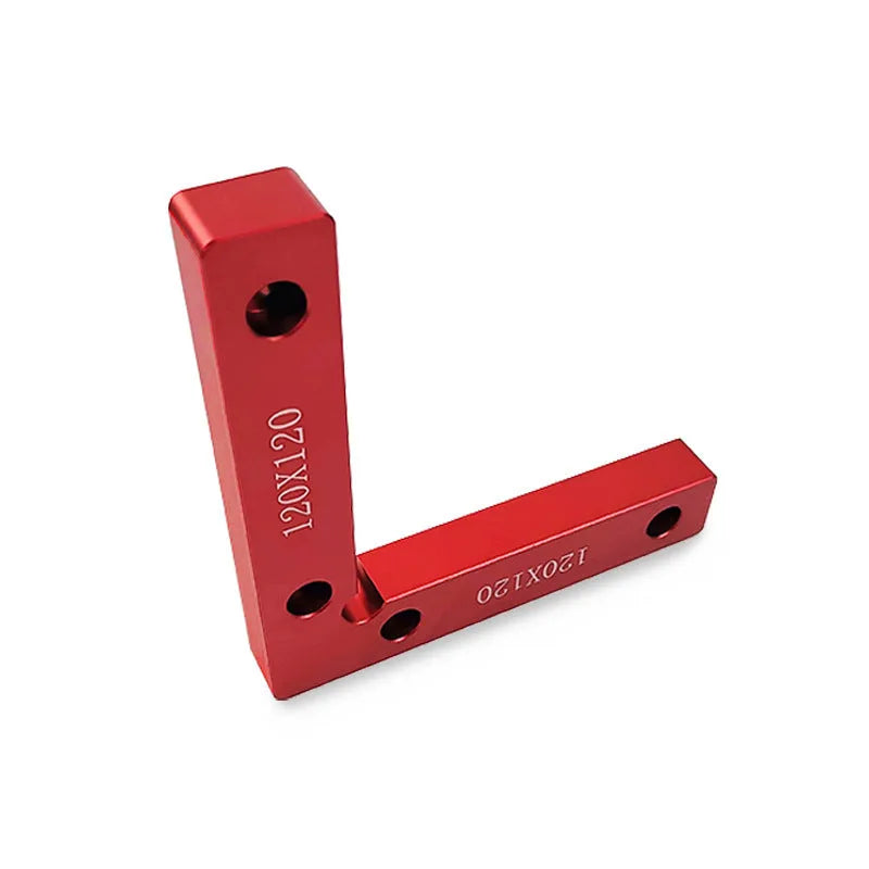 Silver aluminium right angle block clamped to a wooden workbench next to a jigsaw, showing scale markings.