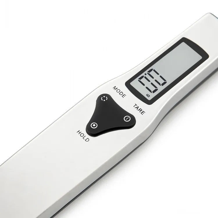 Digital smart measuring spoon with electronic display showing weight, placed on a kitchen worktop.