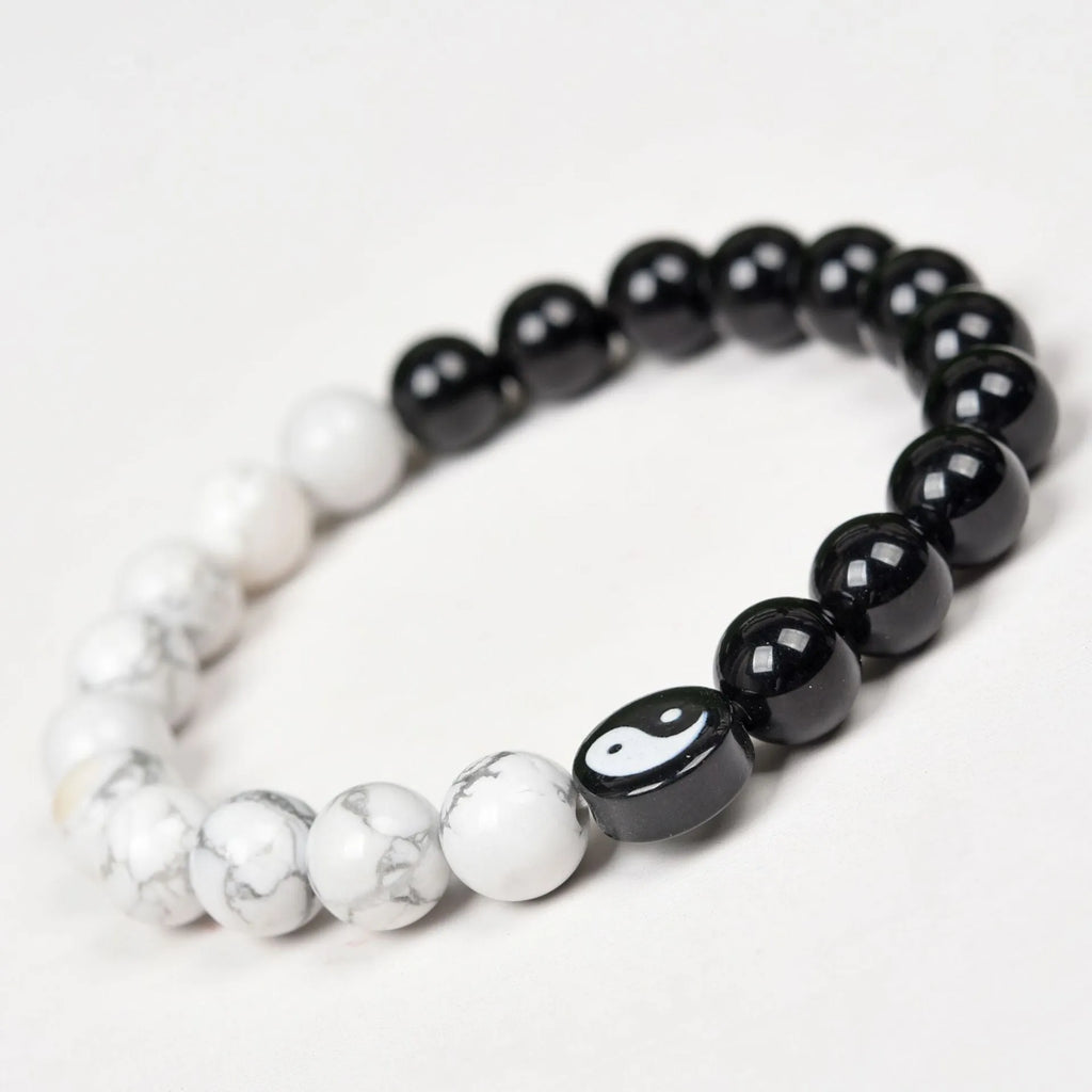 Natural obsidian and white turquoise 8mm bead bracelet on a neutral background