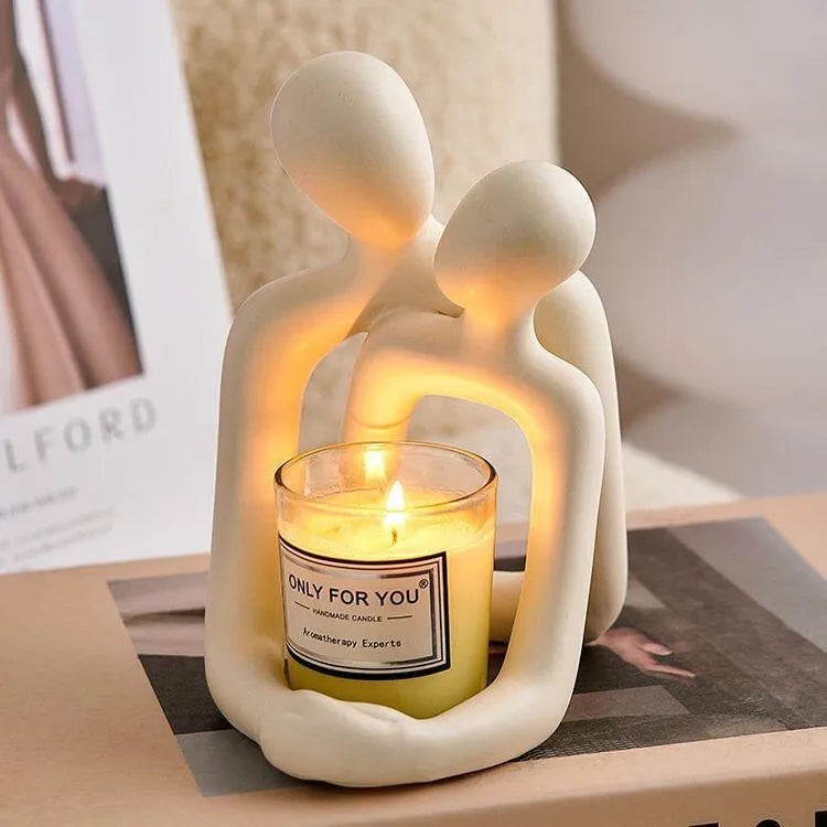 Modern loving couple resin statue in milky white colour on a wooden desk.