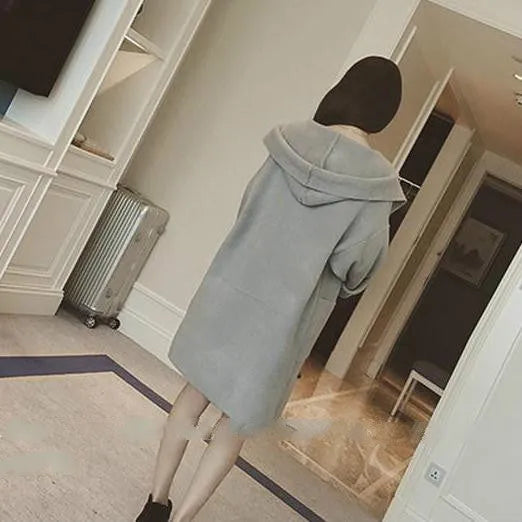 Plus size woman wearing a thin, loose-fit grey coat with lace detail and long sleeves.
