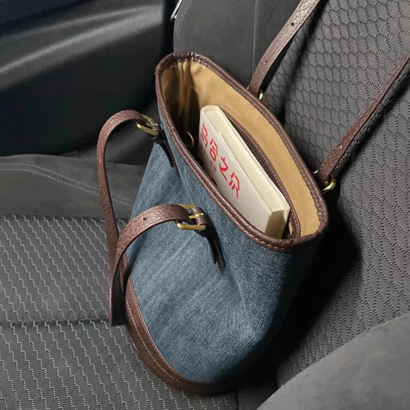 Denim wash patchwork one-shoulder bucket handbag showing front view and strap.