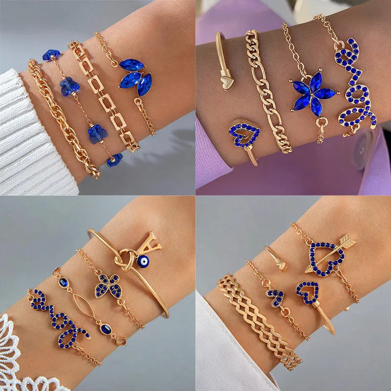 Four-piece blue and gold-tone bracelet set with heart, butterfly, and flower designs, rhinestone accents, alloy electroplated finish