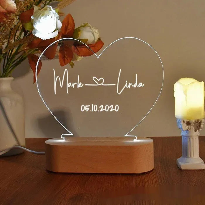 Custom clear acrylic night light displaying personalised names and date, lit by an LED base.