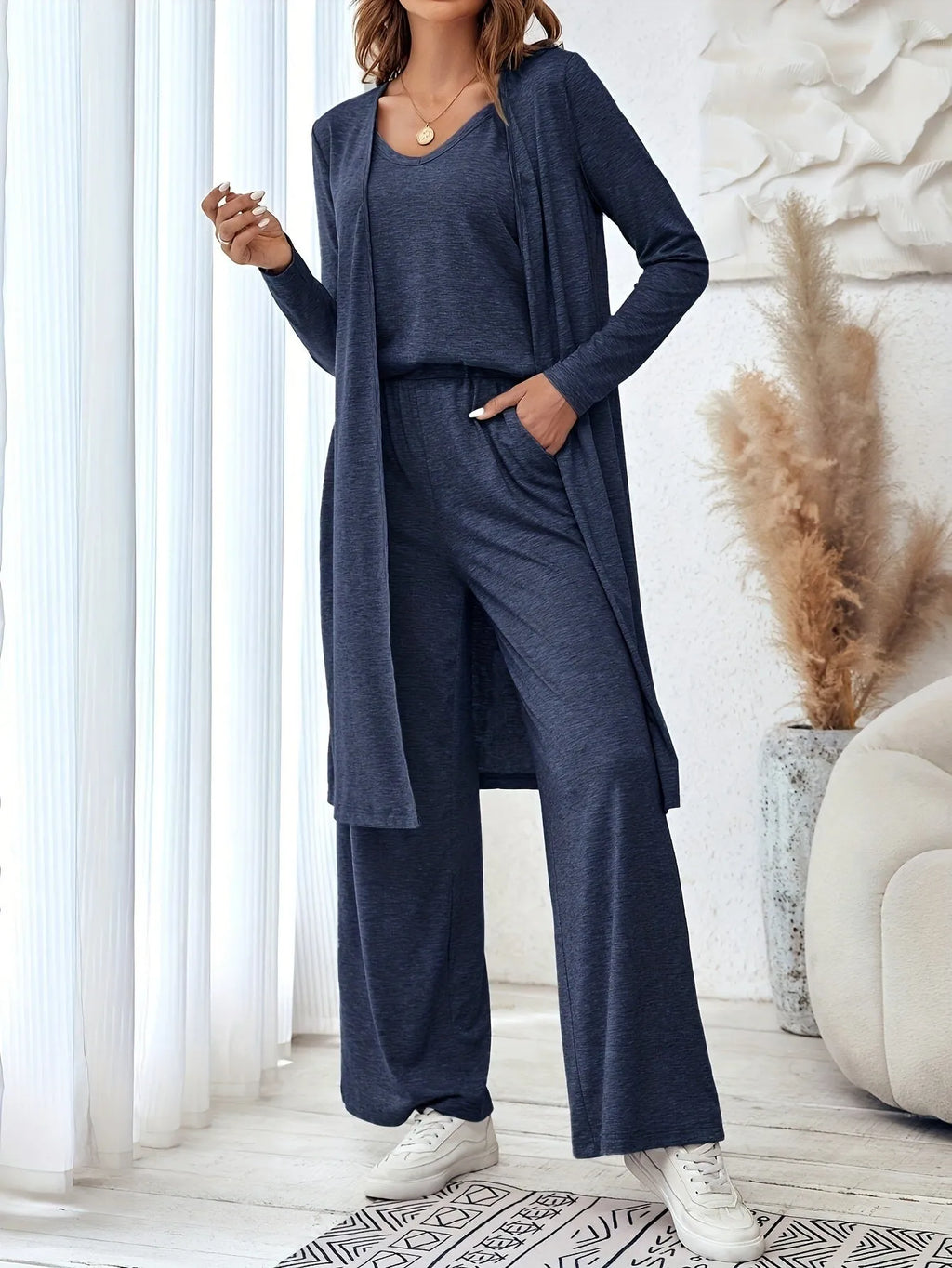 Blue women's three-piece casual suit with sling top, cardigan, trousers, and suspenders.