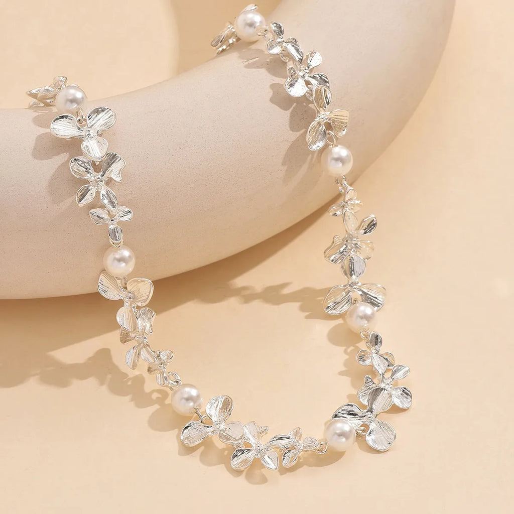 Bright silver alloy flower pearl curved needle clavicle necklace on neutral background