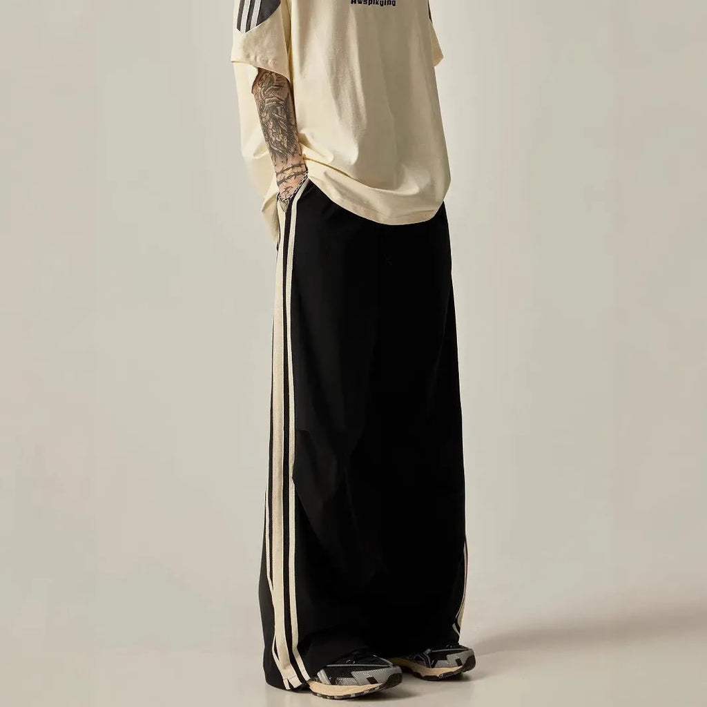 Black men's wide-leg climbing trousers with a high waist on a hanger.