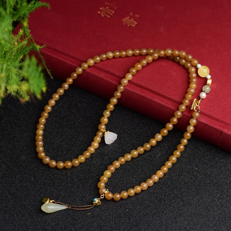 Green pine jade bracelet with 6mm round beads, leaf charms, and sequin accents on wrist