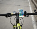 Silicone bicycle phone holder mounted on handlebar with three adjustment holes visible