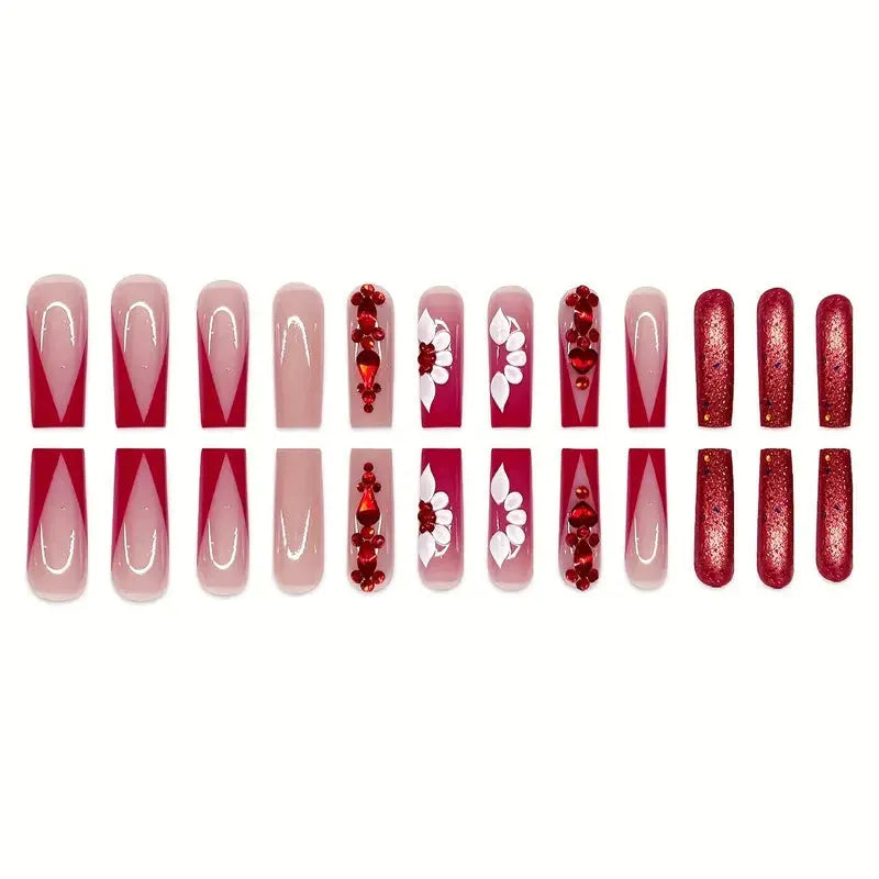 Long almond-shaped false nails with red diamond and floral art in sweet style.