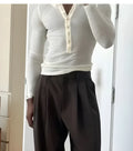 Men's cream ribbed long-sleeve henley top with button-up placket on a hanger.