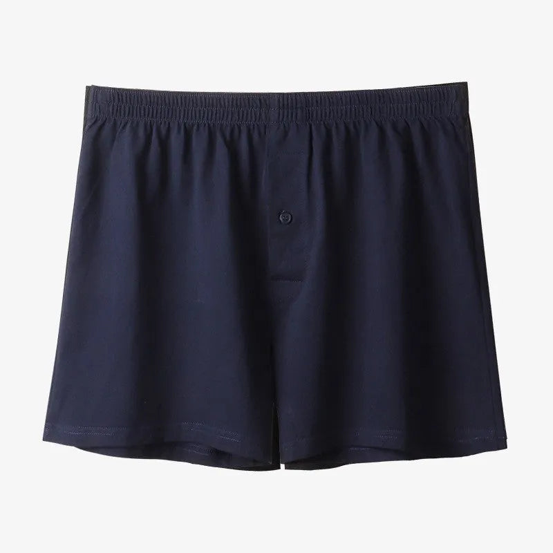 Men's solid colour cotton boxer shorts on a hanger, showing loose fit and high waist.