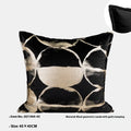 Black and gold abstract pattern decorative square and waist pillow cushions on a grey sofa.
