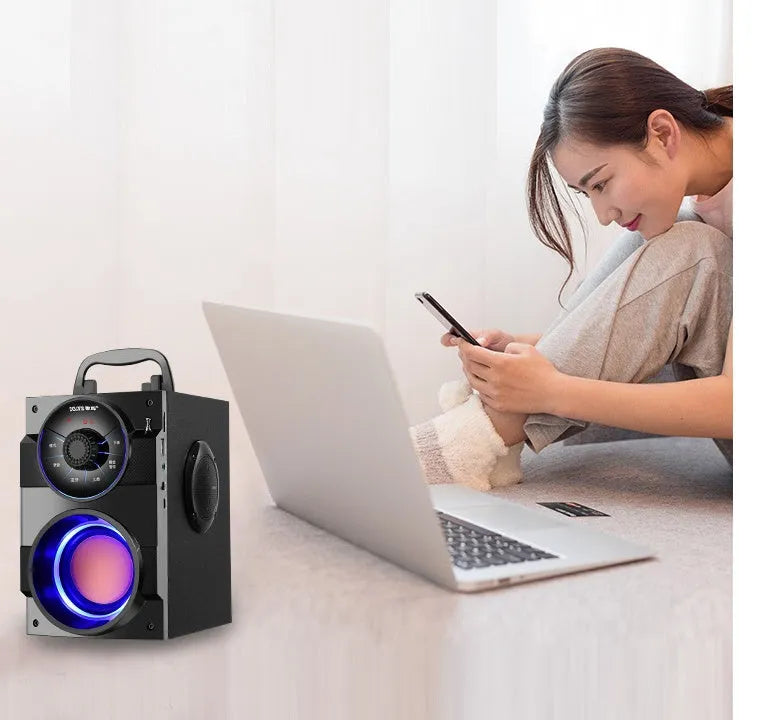 Black portable mini home audio system with subwoofer, cable, and USB power connection.