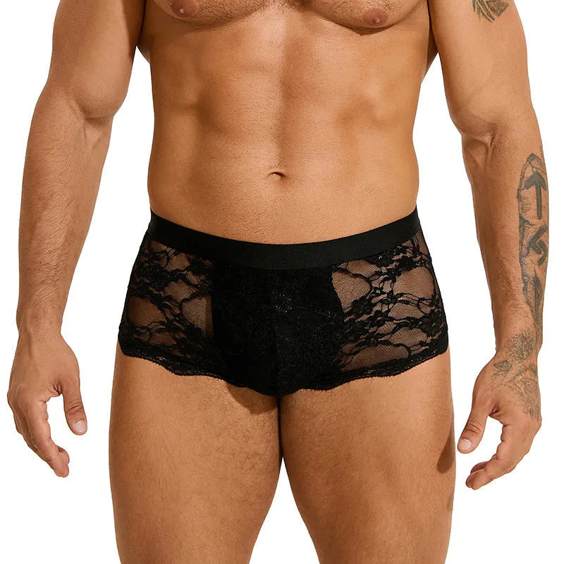 Men's black lace briefs with a hollow-out, see-through design on a neutral background.