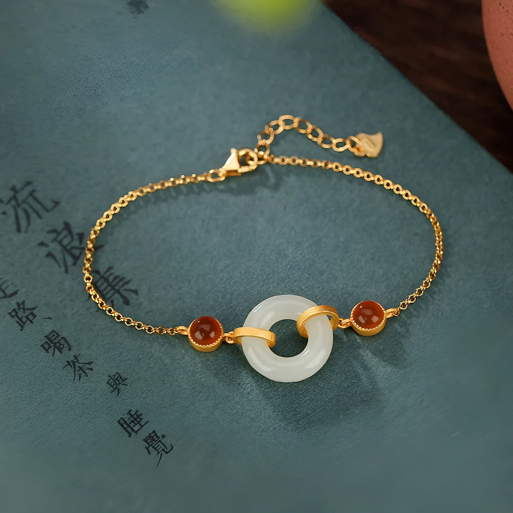 Gold-coloured women's bracelet with a silver base and an inlaid Hetian jade peace buckle charm.
