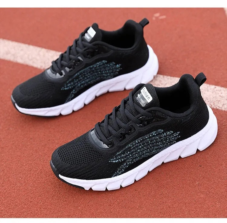 Low-top black and white running sneakers with cross-strap detail and flat MD sole.