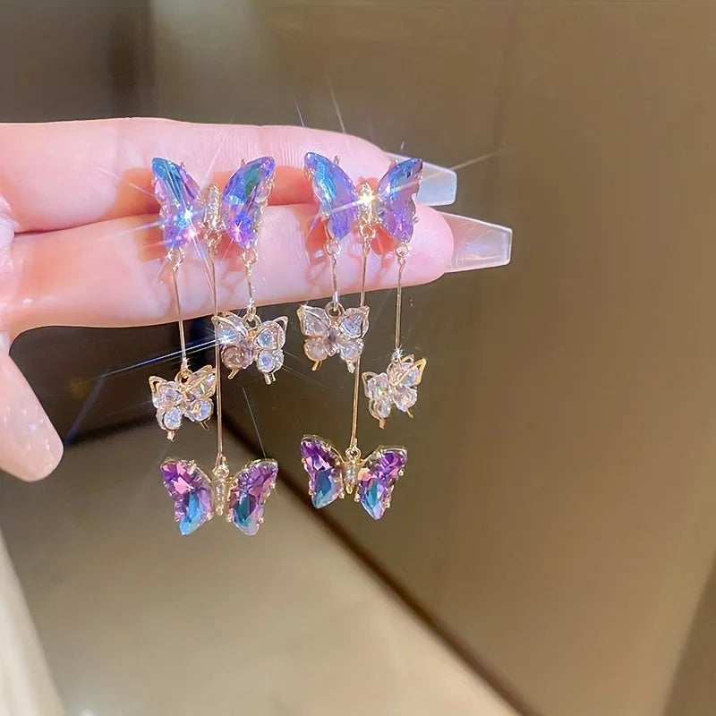 Silver needle and crystal flower earrings with blue purple butterfly tassel on alloy hooks.