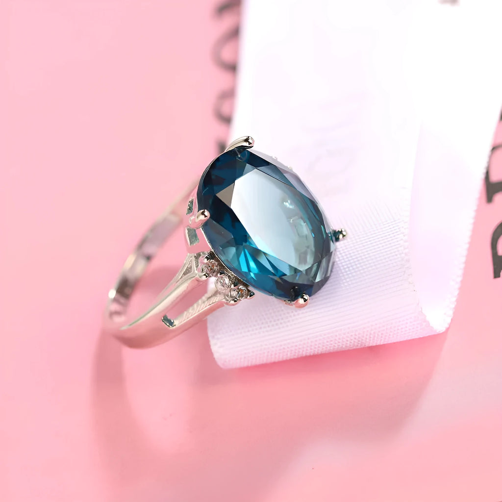 Geometric ellipse shaped zircon ring in electroplated blue black or medium blue copper, showing retro unisex style.