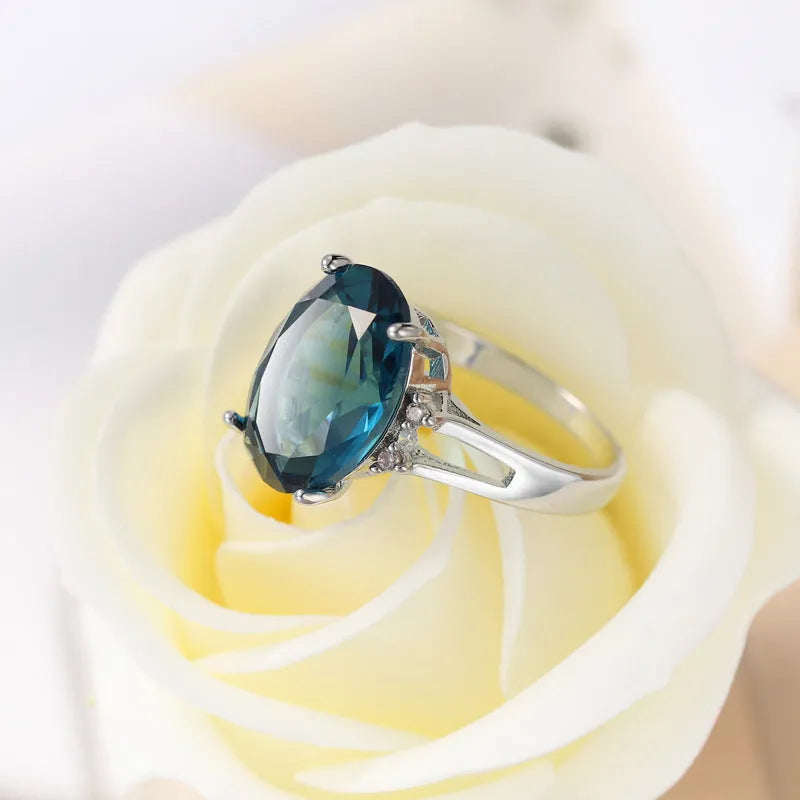 Geometric ellipse shaped zircon ring in electroplated blue black or medium blue copper, showing retro unisex style.