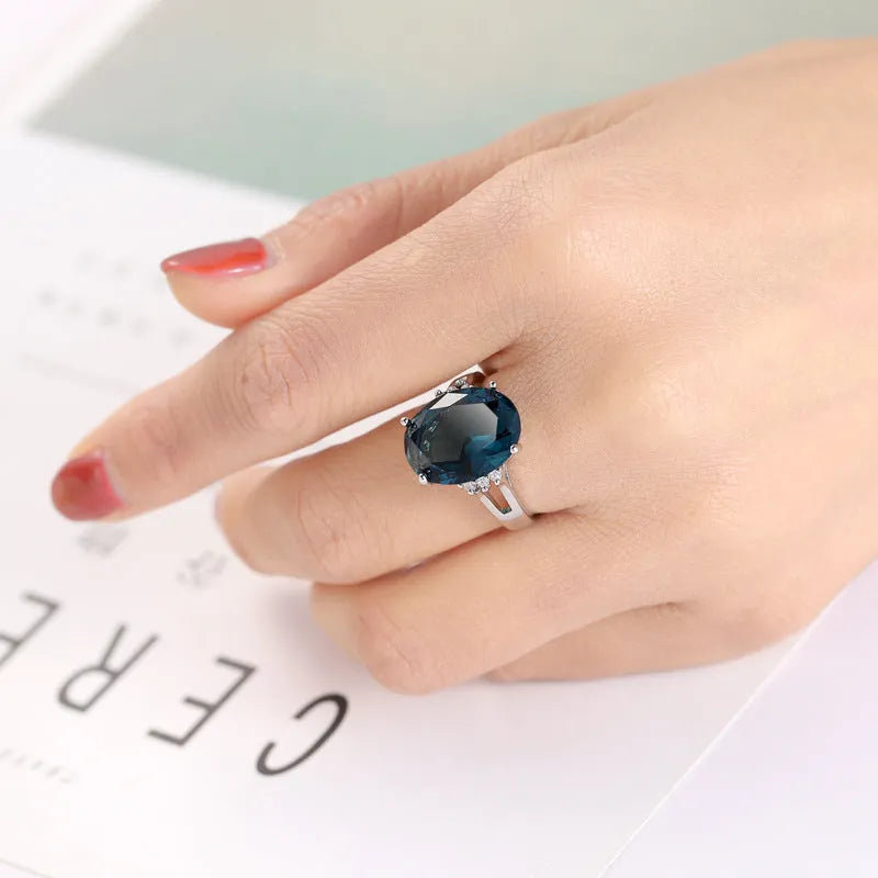Geometric ellipse shaped zircon ring in electroplated blue black or medium blue copper, showing retro unisex style.