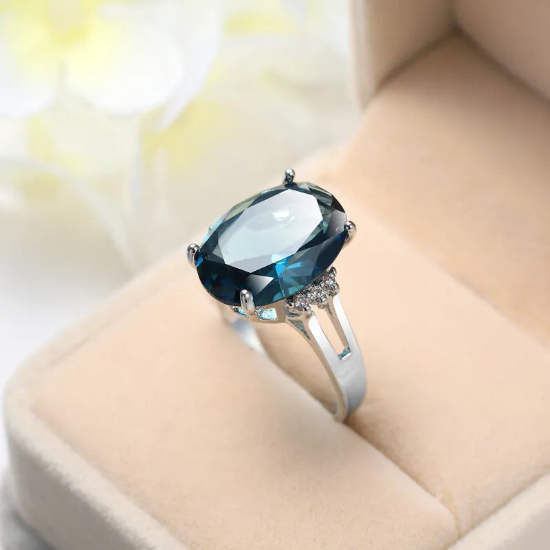 Geometric ellipse shaped zircon ring in electroplated blue black or medium blue copper, showing retro unisex style.