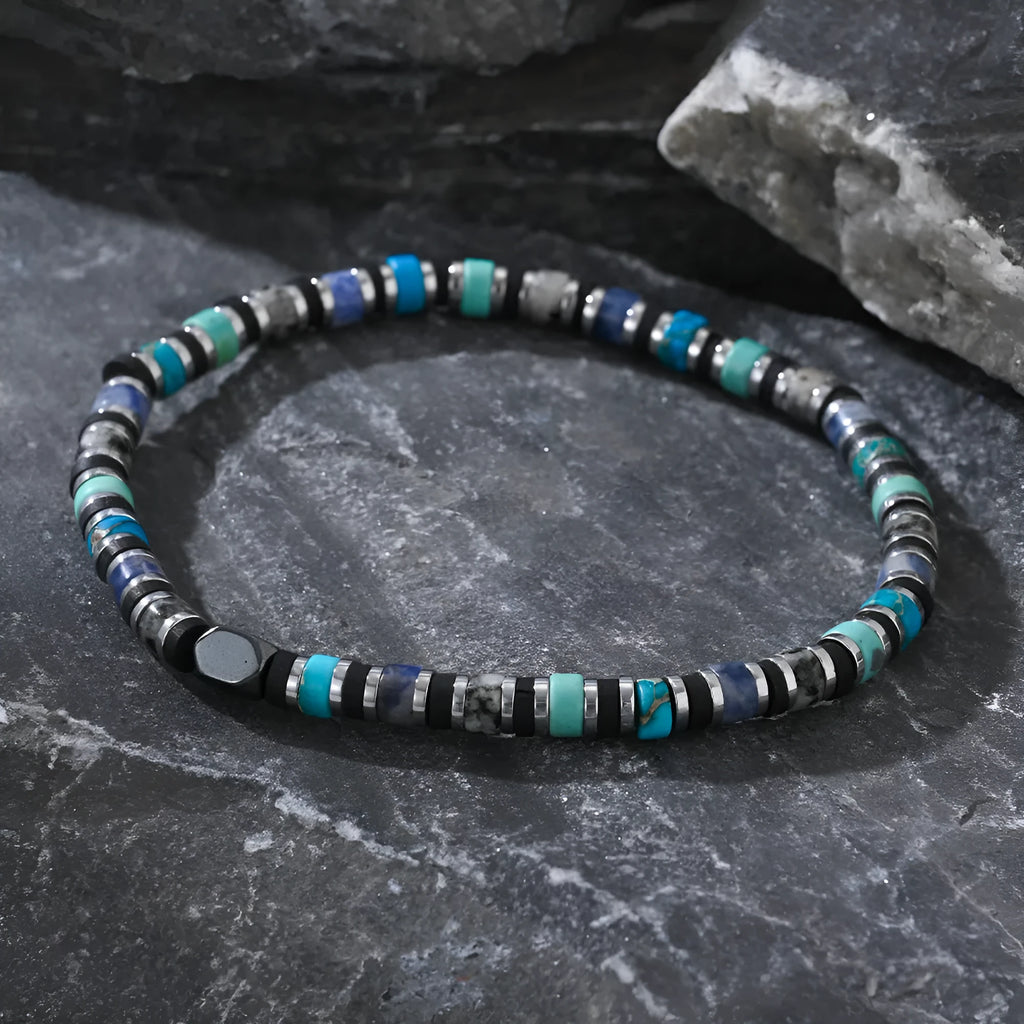 Close-up of a hand-woven cylindrical bohemian bracelet made from natural semi-precious stones in geometric patterns