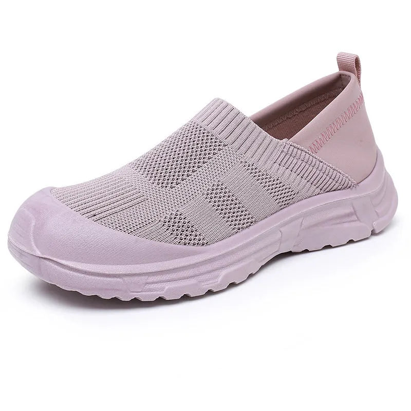 Women's black slip-on shoe cover with breathable cloth upper and flat PVC sole.