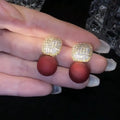 Micro inlaid zircon square pearl stud earrings with tassel detail in copper and imitation pearl, available in three colours: champagne, red, white.