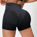 Women's high-waisted gradient fitness shorts in black, shown on a model.