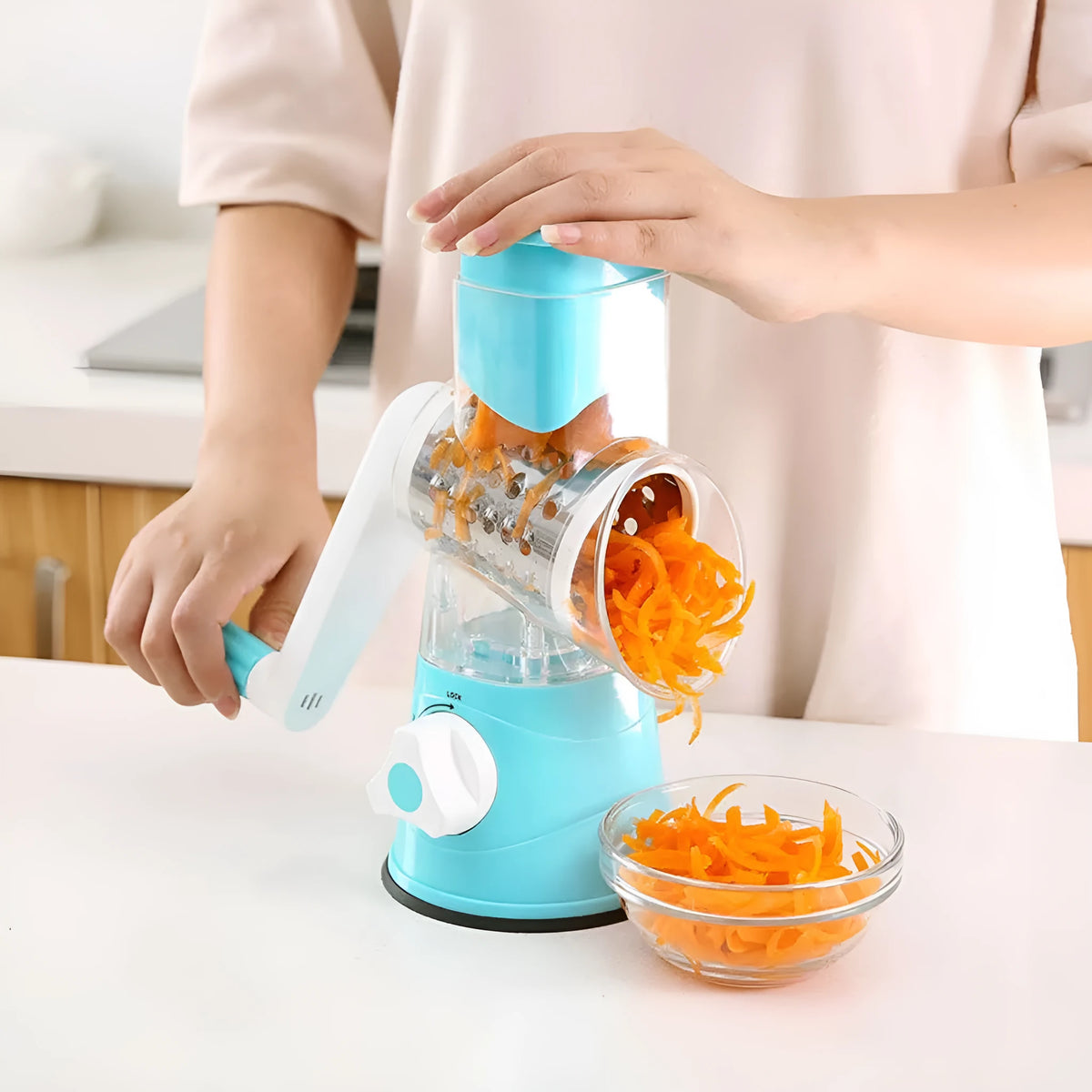 Rotary hand drum grater with stainless steel blades for julienning carrots and potatoes, available in blue, green, or red.