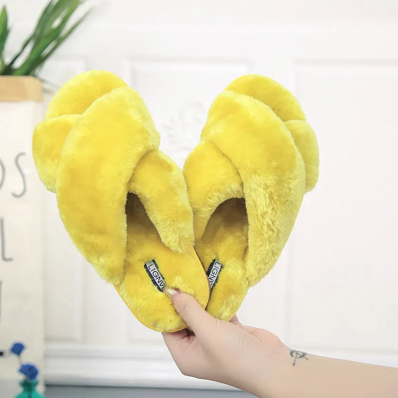 Women's black cross open-toe fur slippers on a white background, showing criss-cross upper and patterned sole.