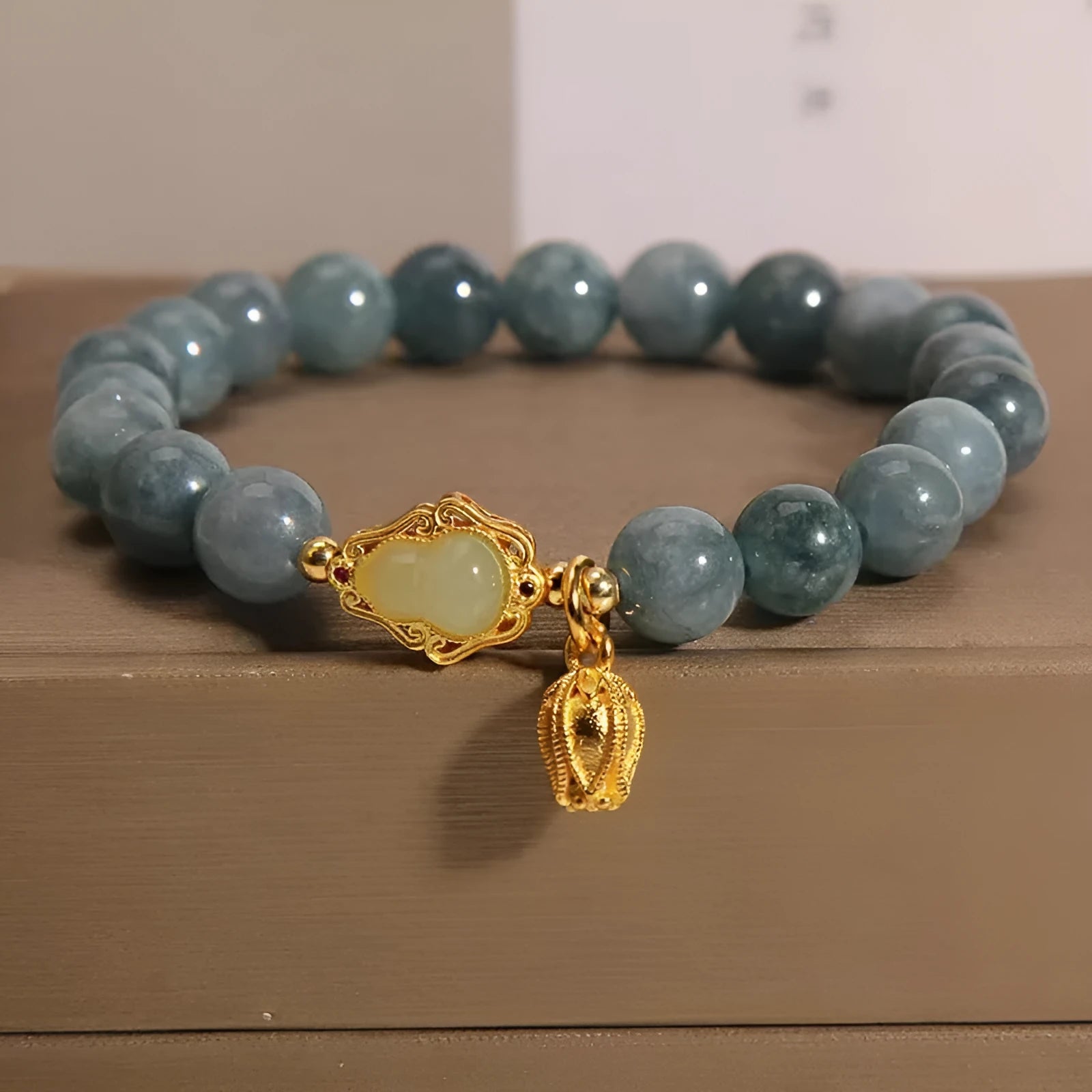 Natural stone bracelet for women with a blue electroplated gourd lotus flower pendant.