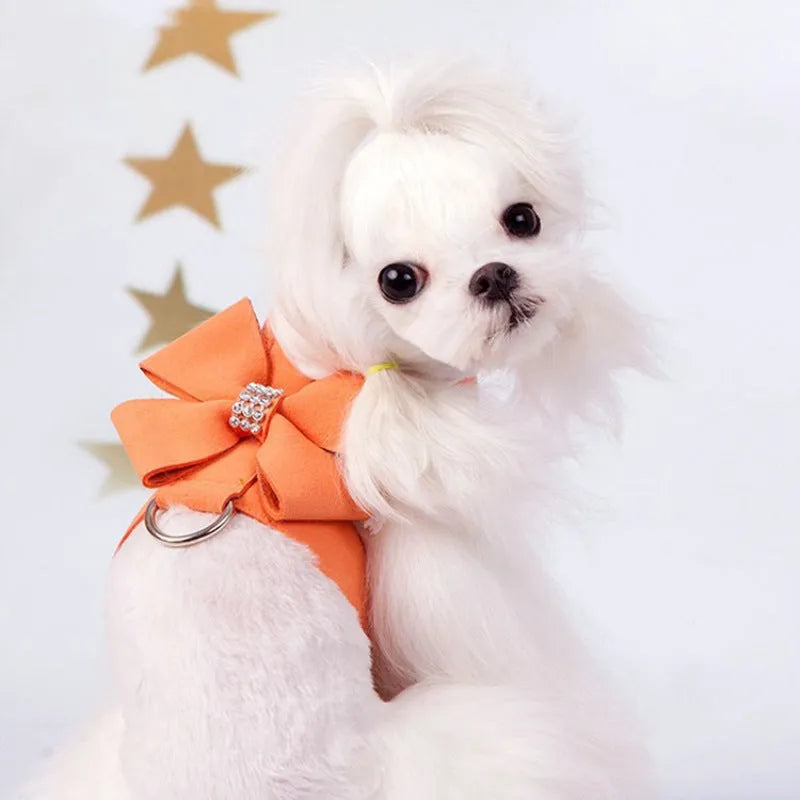 A pink microfiber dog chest strap with a decorative bow, sized for a small puppy.