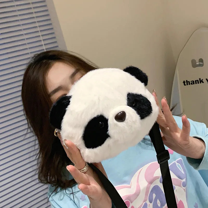 Soft plush crossbody bag in panda head colour with cylindrical shape and sandwich pocket.