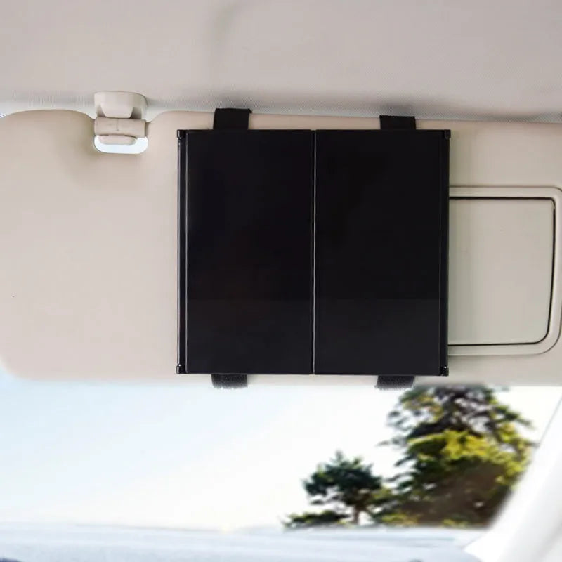 Silver folding car makeup mirror shown both closed and open on a car dashboard.