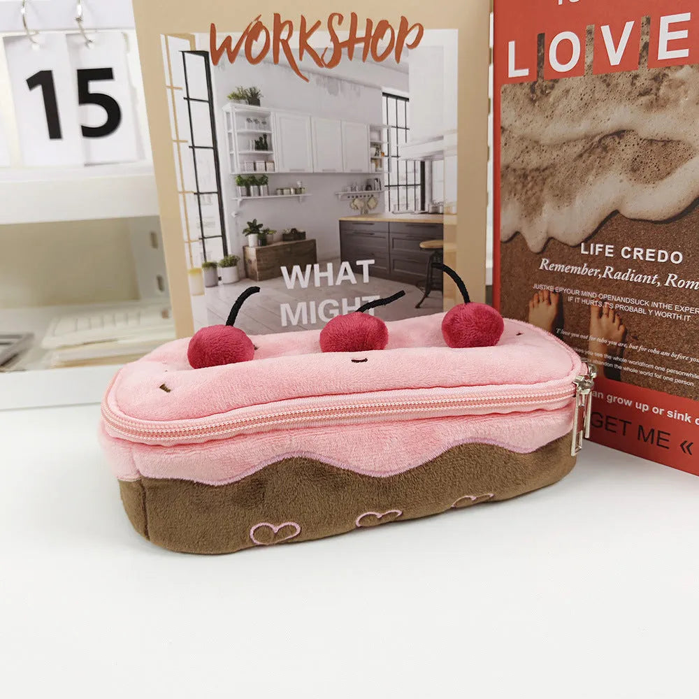 Soft red velvet pencil bag with a cherry cake print and a white zip.