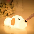 Cartoon dog design USB-charging silicone night lamp in two colours on a surface.
