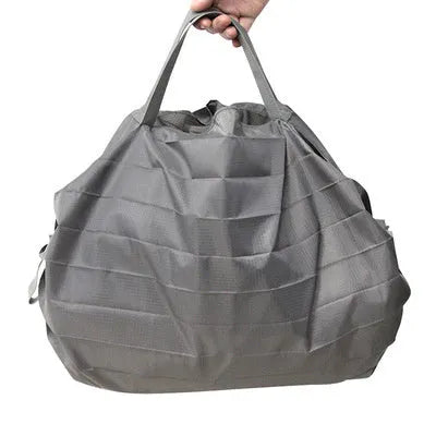 Mini reusable compact grocery bag in light blue, folded and open, made from water-repellent nylon cloth.