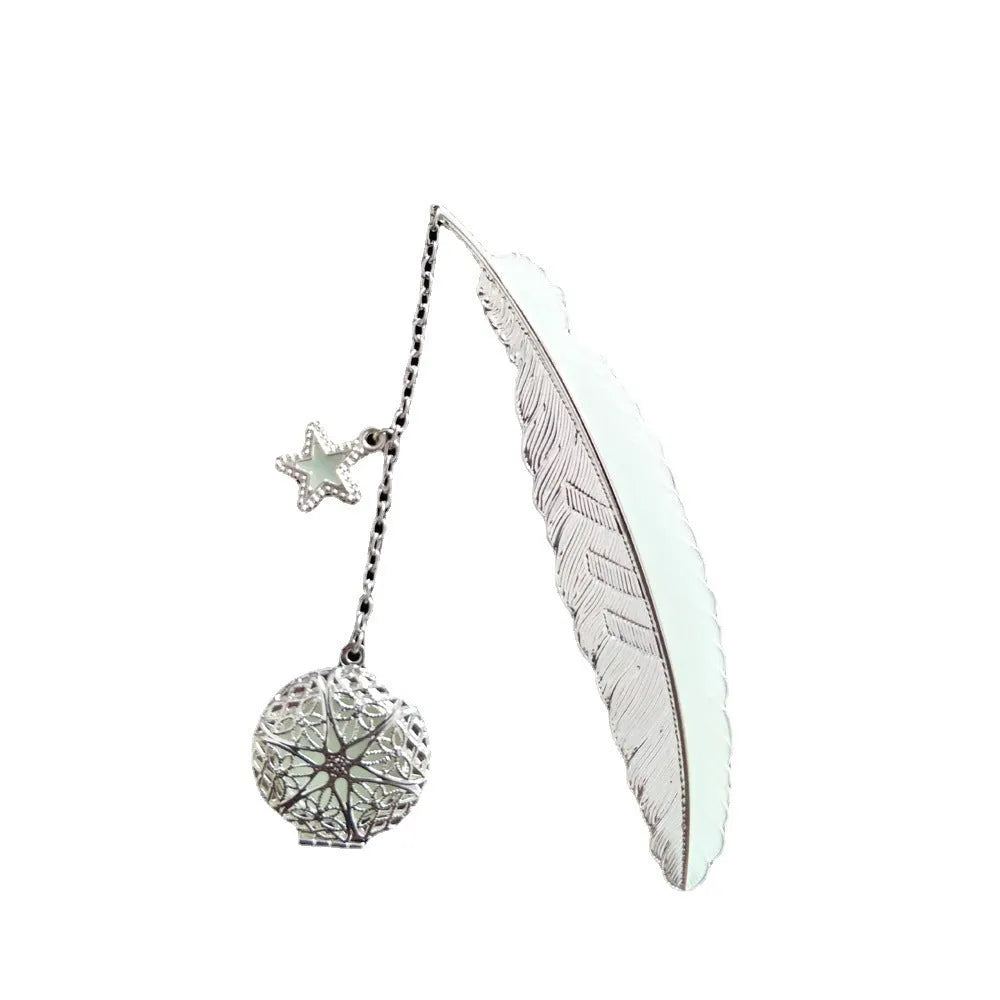 Close-up of a luminous pure copper feather bookmark with engraved celestial design on a book page.