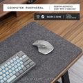 Oversized grey felt and cork office mouse mat on a wooden desk