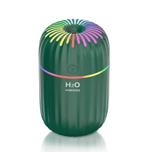 White USB portable mini humidifier with water tank on desk beside laptop