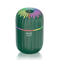 White USB portable mini humidifier with water tank on desk beside laptop
