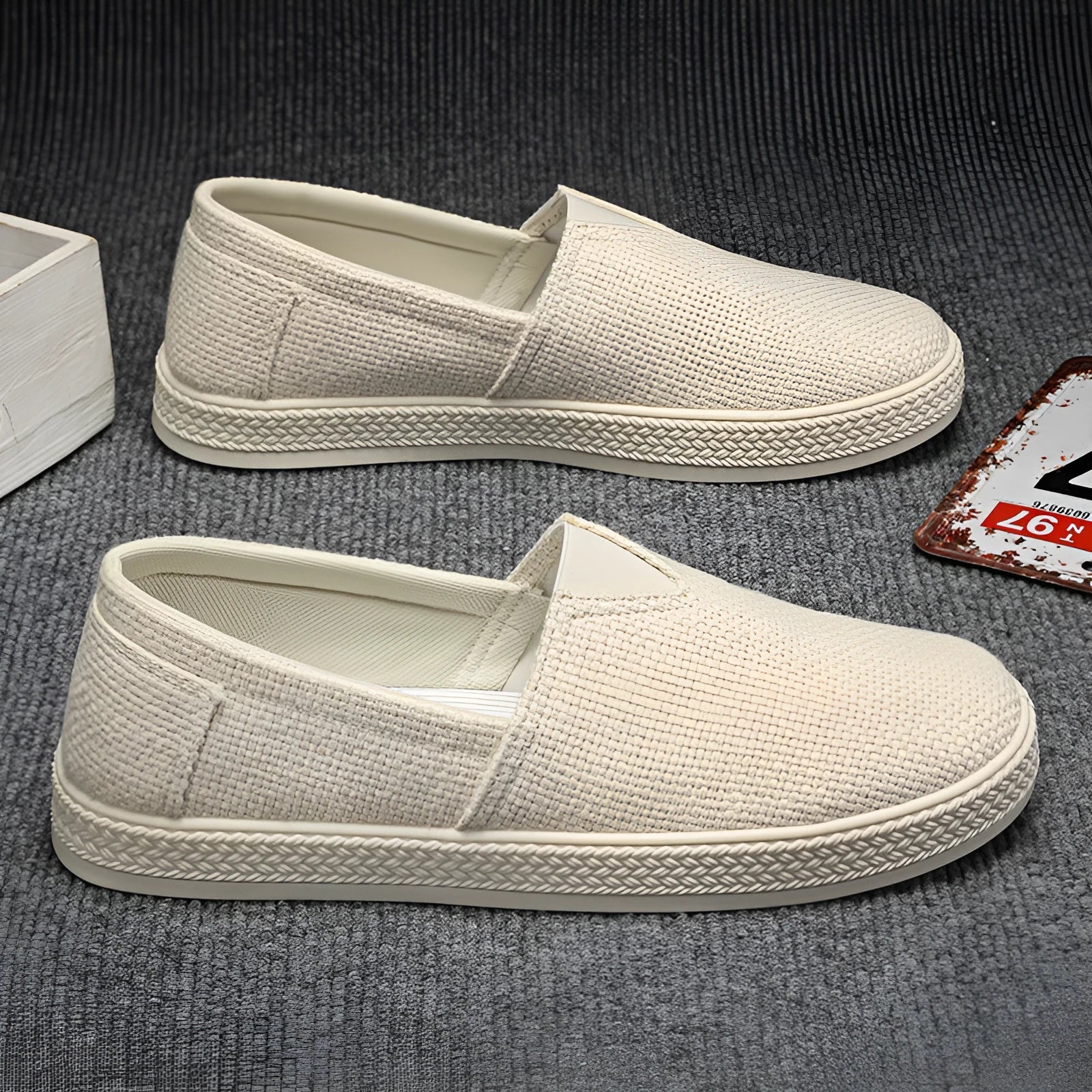 Men's beige canvas slip-on shoes with round toe and PVC sole on neutral background